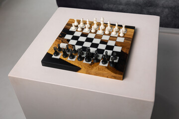 Chessboard featuring a complete set of white and black chess pieces arranged and ready for a game. © Natalya Likhina