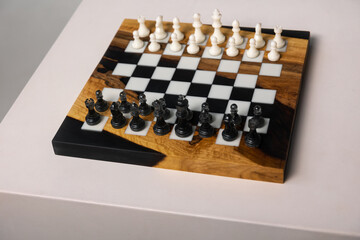 Chessboard featuring a complete set of white and black chess pieces arranged and ready for a game. © Natalya Likhina