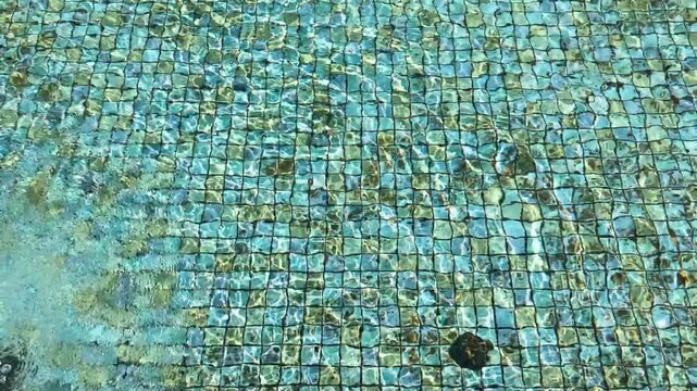 Concentric Water Ripples on Blue Mosaic Pool Bottom