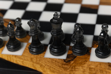 There are black pieces on the chessboard: pawns, a knight, a bishop, and a rook. Selective focus on the black pieces. © Natalya Likhina
