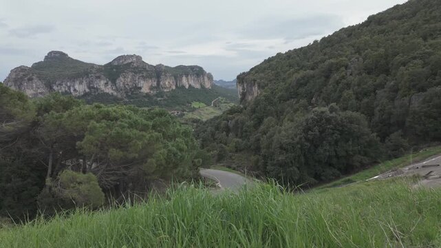 High Angle of Winding Rural Road and Rugged Limestone Mountain Landscapes in Baunei Near Pedra Longa Sardinia