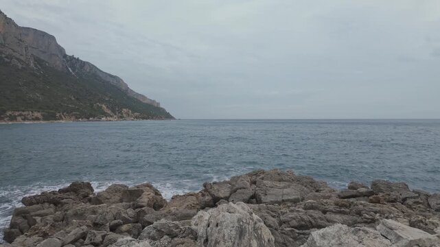Panoramic Sea Waves Crashing on Rugged Rocky Coastline and Steep Cliffs at Pedra Longa Sardinia