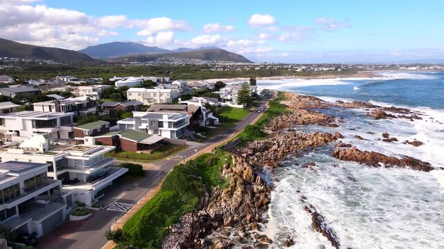 Drone view of ocean waves crashing on rocky shore of Onrus, Hermanus