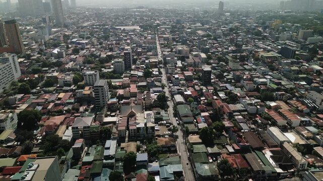 Aerial flyover of San Roque in Quezon City showing dense residential blocks, long roads, and Metro Manila urban sprawl - Philippines
