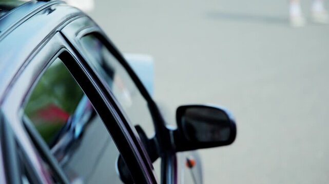 Close up view of car door experiencing intense vibrations caused by powerful bass sound from installed subwoofer system. Glass window and frame shake dramatically, showcasing audio power.