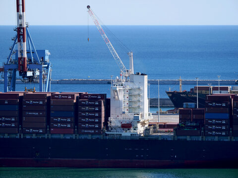 Genoa, Italy - June 2026: a commercial vessel with Zim and Tex containers on deck, moored at the Sech terminal.