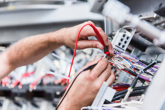 Close-up of man using voltmeter in factory