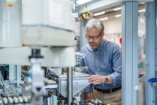 Engineer checking industrial robot machinery in modern factory