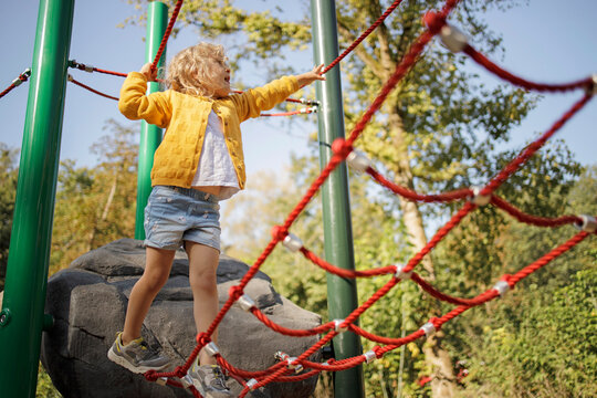 Girl playing on jungle gym at playground