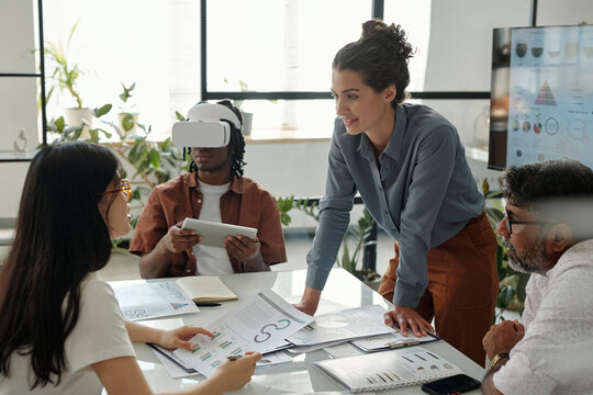 Team brainstorming in an office with VR technology and documents