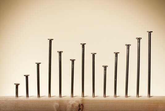 Row of nails in wood arranged as a statistical graph