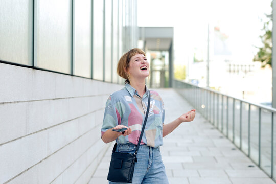 Portrait of young woman with smartphone freaking out