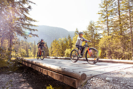 Mother and daughter riding e-mountain bikes in the mountains