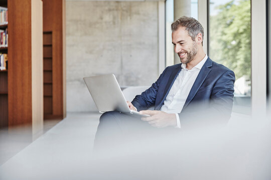 Smiling businesssman using laptop