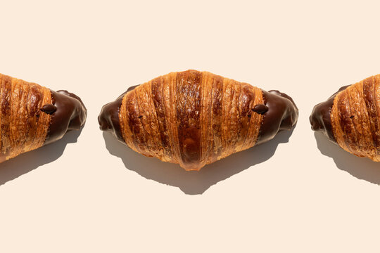 Tempting chocolate croissants on beige background