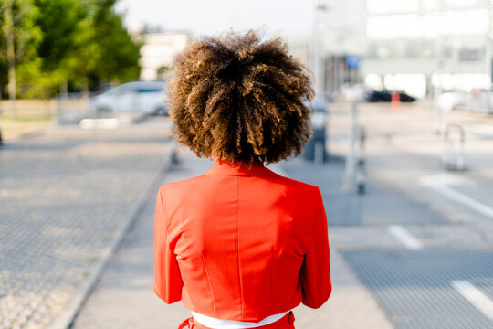Back view of young woman wearing fashionable red suit jacket