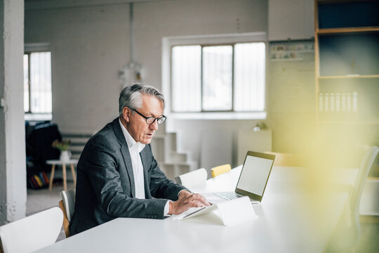 Senior businessman using tablet at table