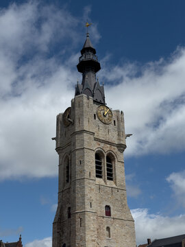 Historic Bethune belfry clock tower under blue cloudy sky