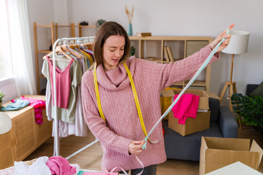 Clothing designer measuring a zipper in a colorful home studio