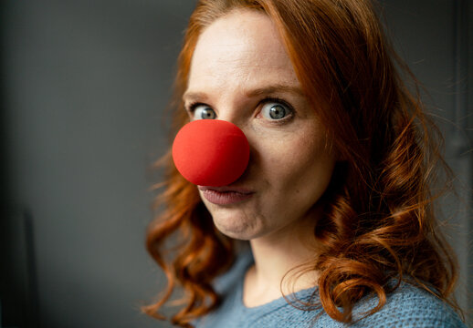 Portrait of redheaded woman with clown's nose