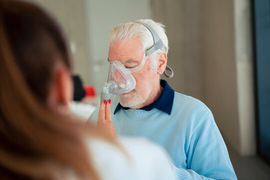 Doctor helping patient using nebulizer