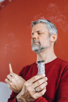 Businessman meditating with burning sage and incense for mindfulness