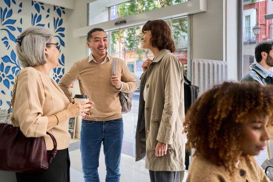 Smiling colleagues talking and networking in a modern office