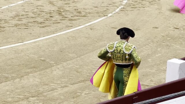 Torero matador en plaza de toros con capote, traje de luces y montera maestro en albero tauromaquia con cuadrilla subalternos en ruedo lidia, faena, burladero y tablas contrabarrera en festejo taurino