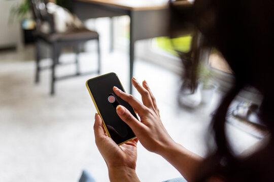 Woman turning off smart phone at home