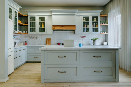 Modern cozy kitchen interior with island and laptop on countertop