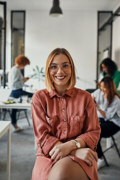 Portrait of a confident businesswoman in office with colleagues in background