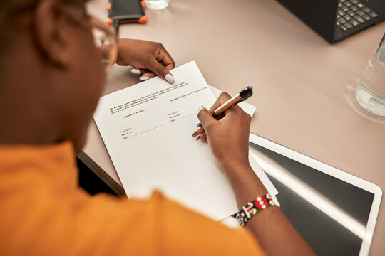Businesswoman signing contract at desk in office
