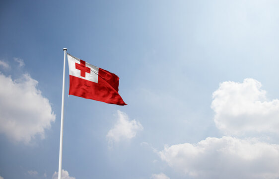 Tonga flag waving in sky with long mast.