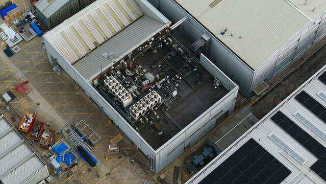 Aerial view of industrial ventilation and cooling fans installed on a flat rooftop of a warehouse facility in Stevenage, England, United Kingdom.