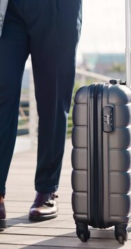 Business travel, legs and hand with suitcase in city, walking and lawyer on urban street or journey. Outdoor, attorney and person with international career opportunity, feet and commute with luggage