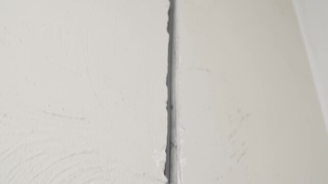 Slow camera movement toward electrical wiring and junction boxes embedded in concrete. Electrical system installation during construction and renovation stage.
