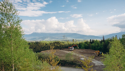 Heavy machinery preparing building site in mountains © Iryna