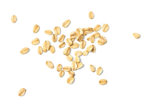 Scattered oat flakes on a clean white background.  Top view of oat flakes isolated.