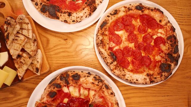 Overhead View of Pepperoni Pizza and Italian Charcuterie on Wooden Table