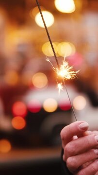Girl Holds A Bright Burning Sparkler In Hand At The Christmas Fair, Vertical Video
