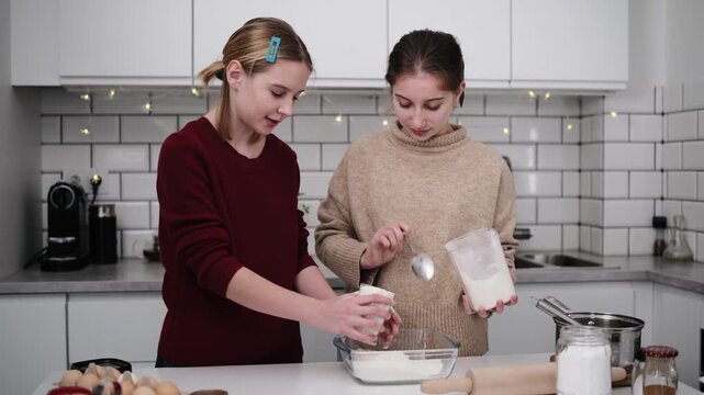 Sisters Bake Gingerbread Cookies For Christmas, Pouring Flour Into The Dough Mixture
