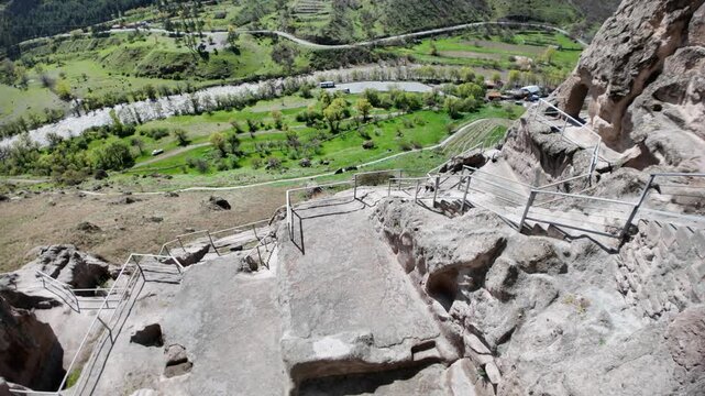 walkway carved into Erusheti Mountain cliffside at the ancient Vardzia cave monastery complex, overlooking the Kura River valley in Georgia