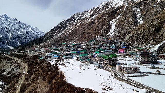 Scenic Aerial View of Chitkul Village Covered in Snow with Himalayan Mountains, Snowy Landscape, Traditional Mountain Homes, Frozen Winter Scenery, Cloudy Sky and Beautiful Kinnaur Valley Nature View