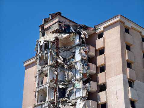 Building collapse in urban area during clear weather under bright sky