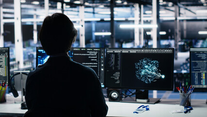 Obraz premium Engineer checks infrastructure diagnostics on a digital device in a server room for IT maintenance.