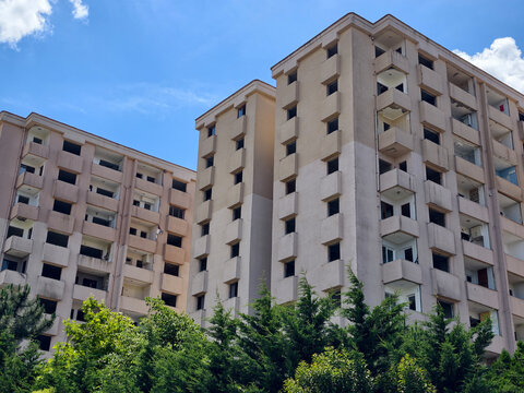 Building structure with multiple floors and balconies under blue sky in an urban area