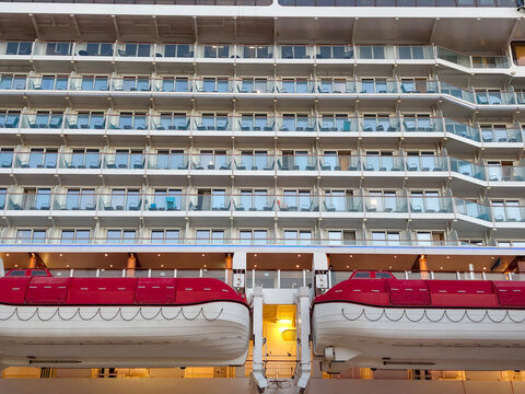 View of cruise ship balconies and lifeboats at port during daylight hours