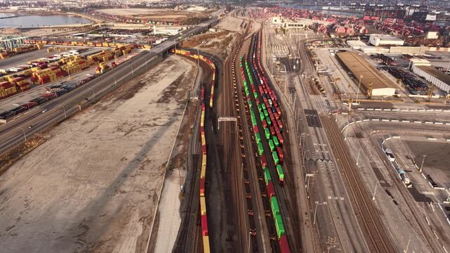 A long freight train rolls toward the Port of Los Angeles carrying containers from across the country. The trains immense length viewed from the air.