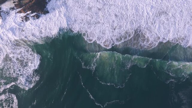 Aerial overhead waves breaking on the coastline