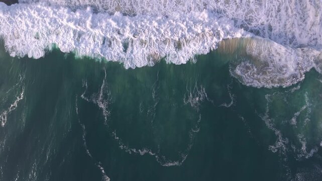 Aerial overhead waves breaking on the coastline
